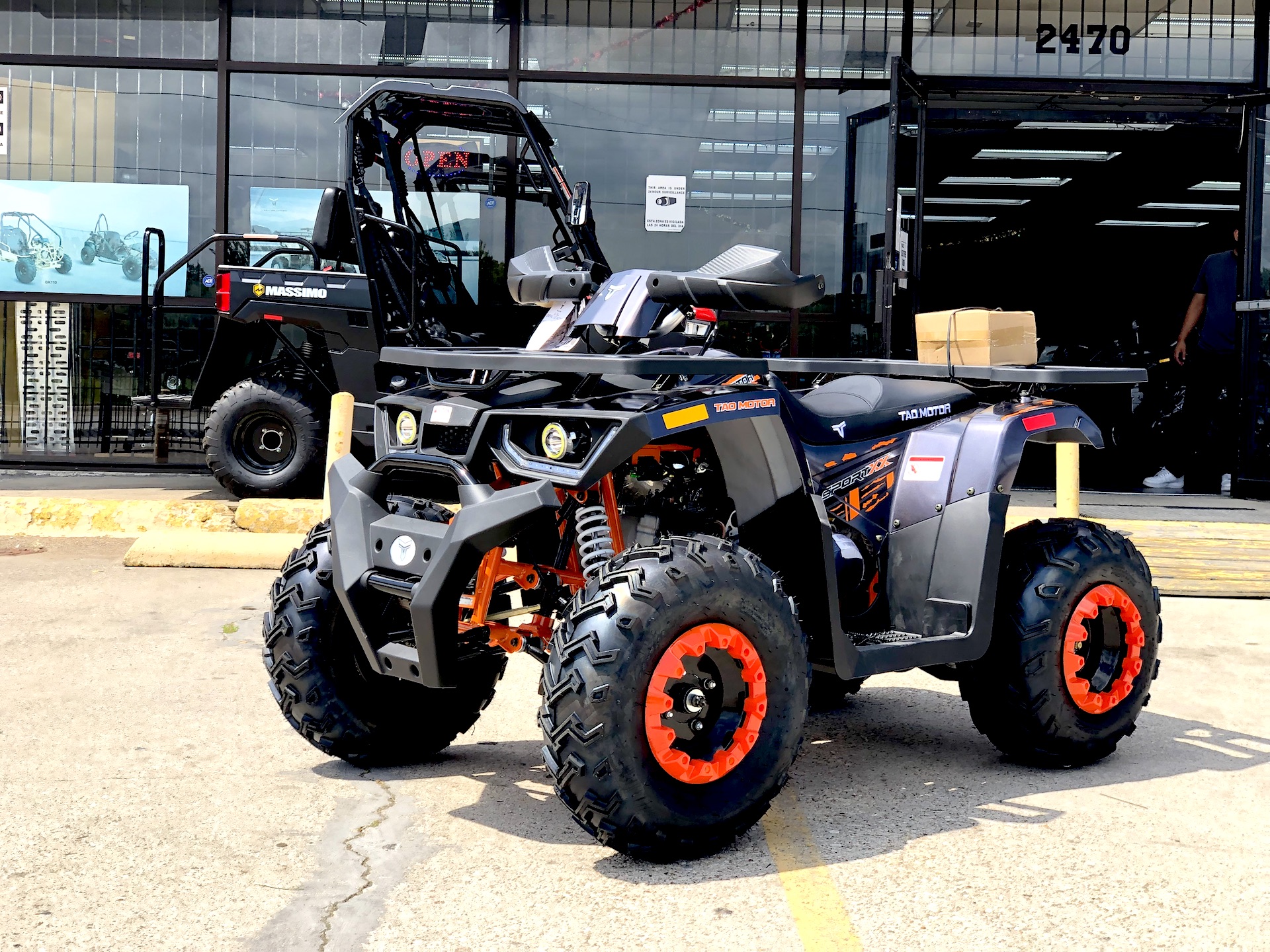A black and orange atv parked in the street.