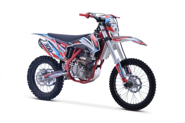 A red, white and blue dirt bike is parked on the ground.