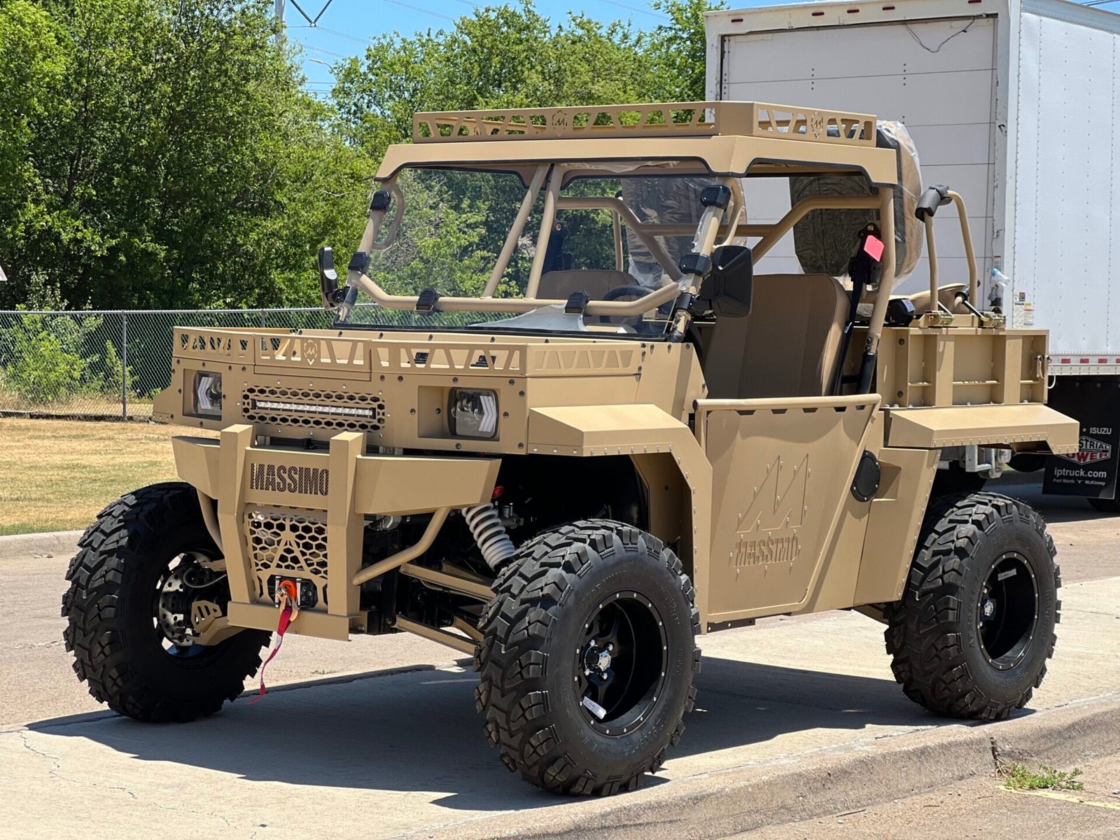 A tan military vehicle parked on the side of a road.