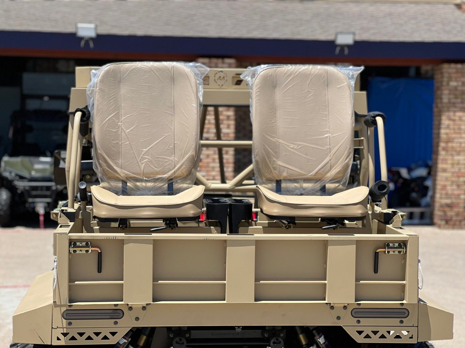 A military vehicle with two seats wrapped in plastic.