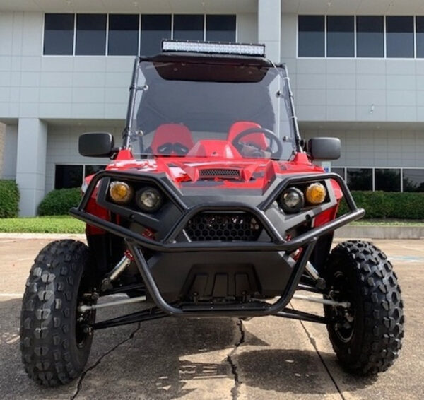 A red and black buggy parked in front of a building.