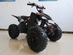 A black four wheeler sitting on top of a white floor.