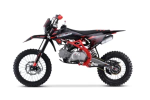 A red and black dirt bike is parked on the ground