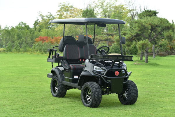 A black golf cart is parked in the grass.