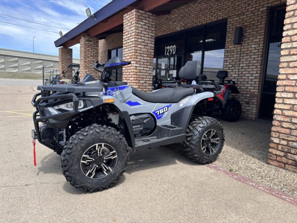 A blue and silver atv parked in front of a building.