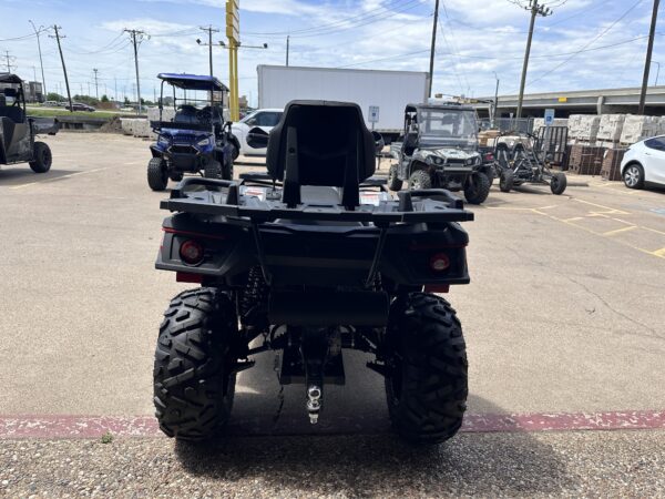 A black four wheeler parked in the middle of a parking lot.