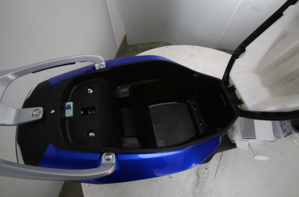 A blue scooter seat in the middle of a room.