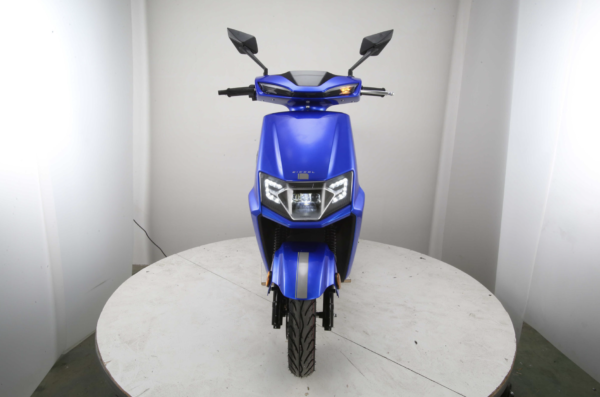 A blue scooter is parked on top of a table.