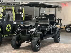A black golf cart with lots of wheels and tires.