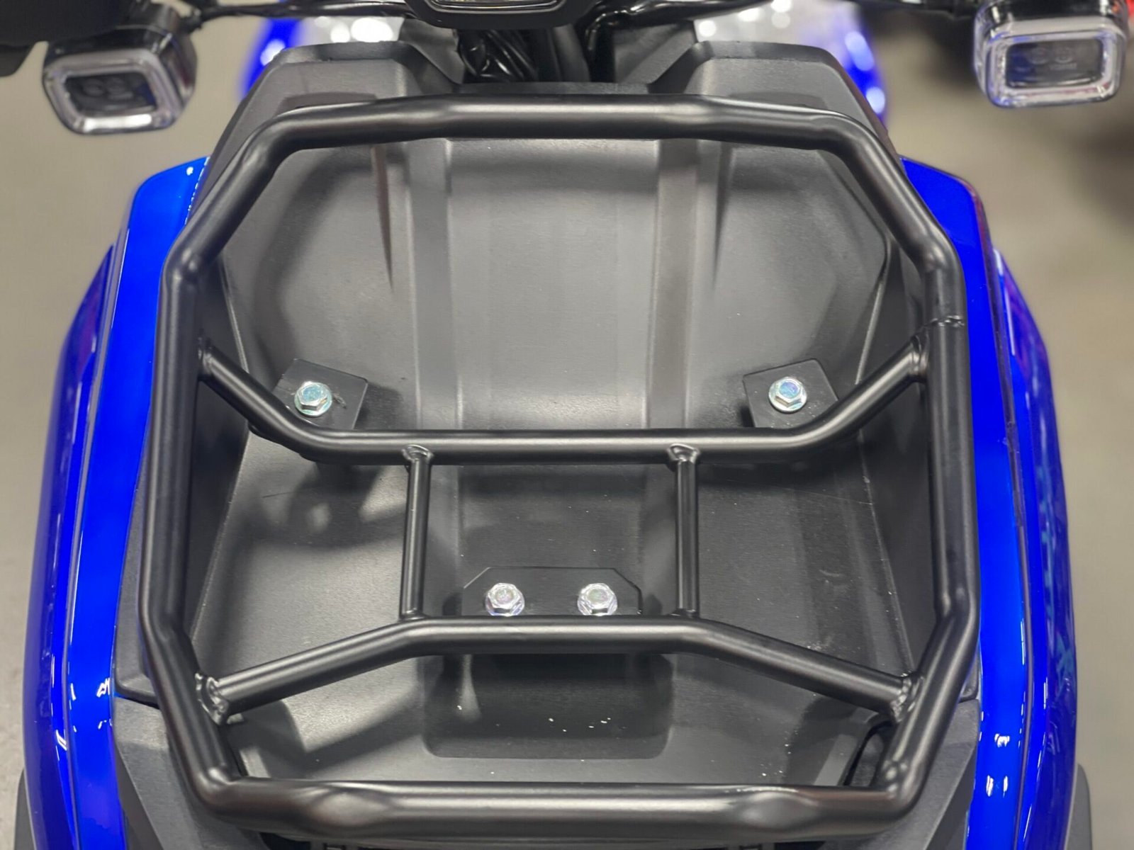 A blue and black motorcycle with a seat on it