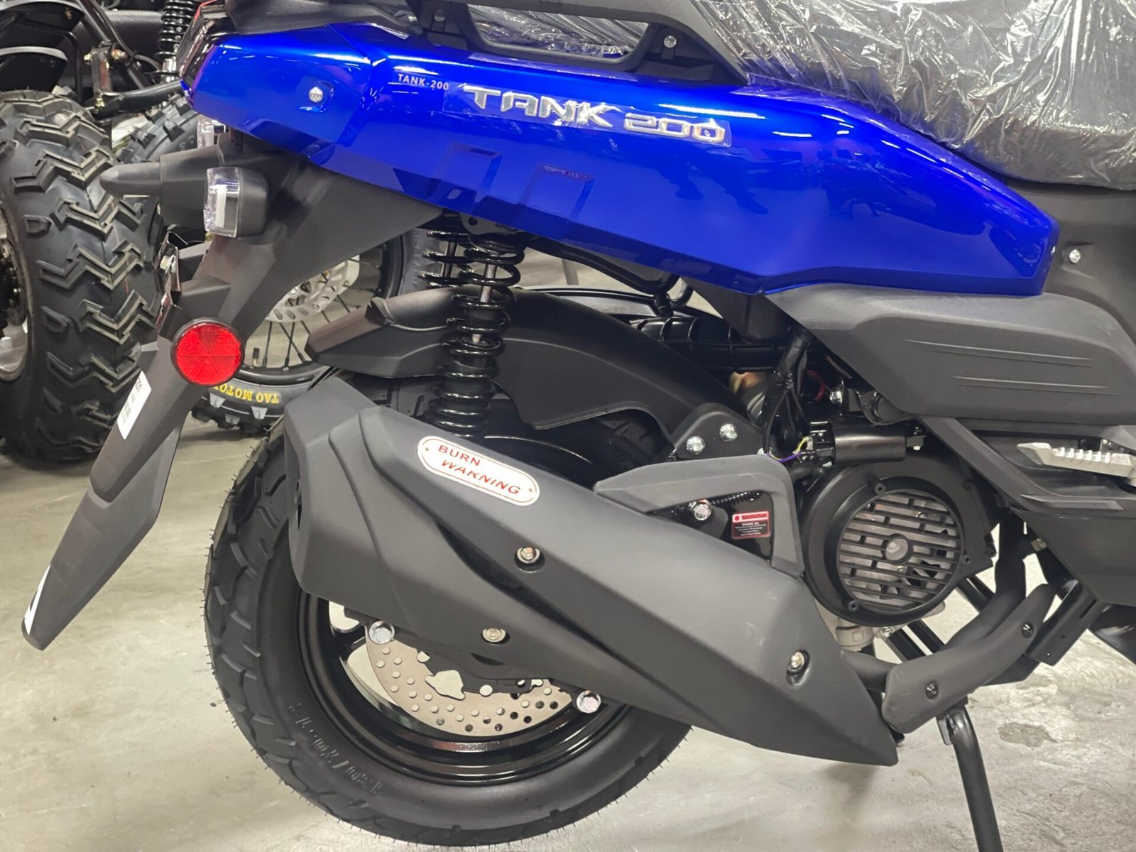 A blue motorcycle is parked in the garage.