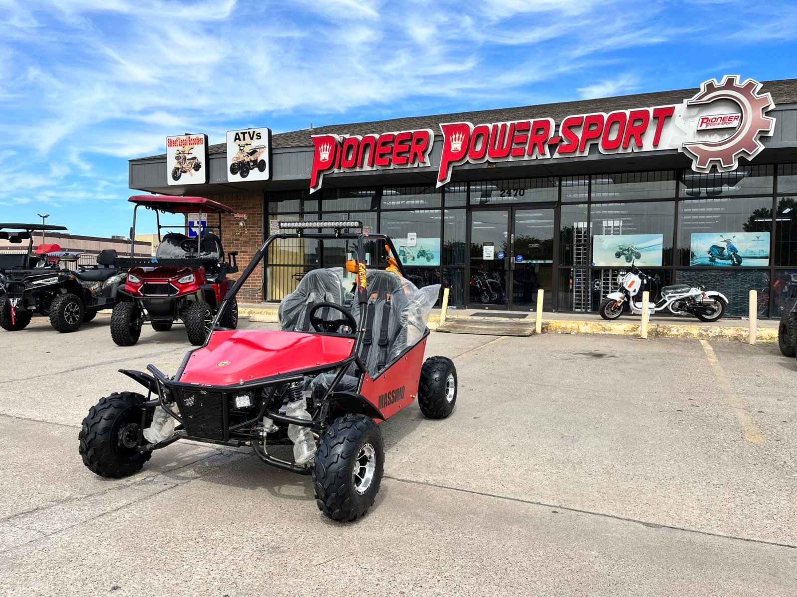 A red dune buggy parked in front of a building.