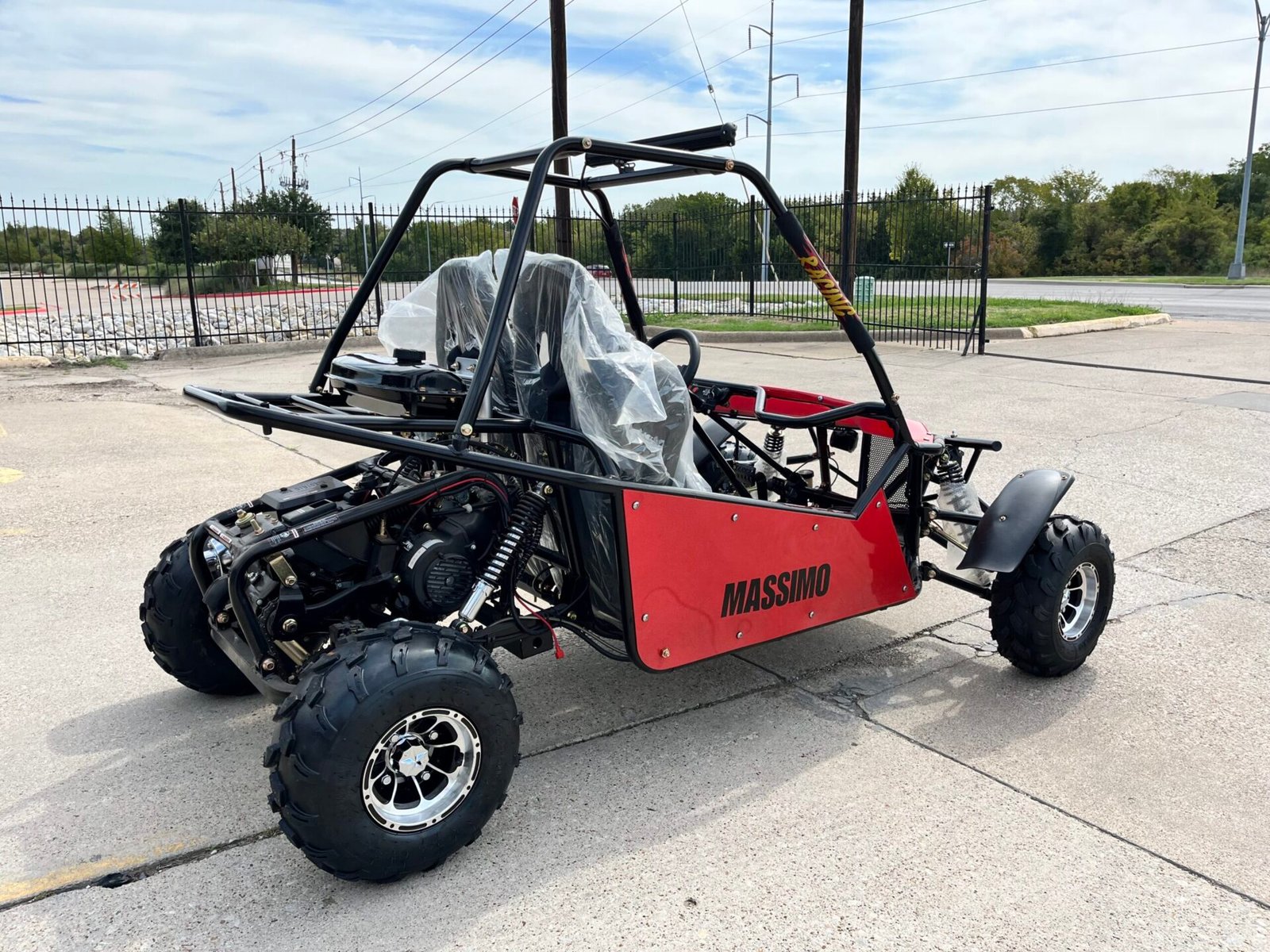 A red and black go kart parked on the side of road.