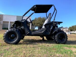 A black and silver atv parked in the grass.