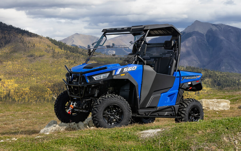 A blue and black utility vehicle parked on top of a hill.
