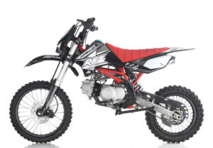 A red and black dirt bike is parked on the ground.