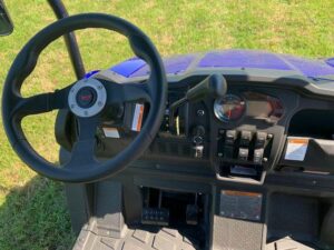 A steering wheel and controls of an atv.